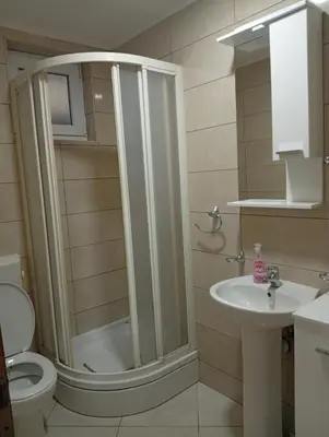 a bathroom with a shower and a toilet and a sink at Apartman Školska in Travnik