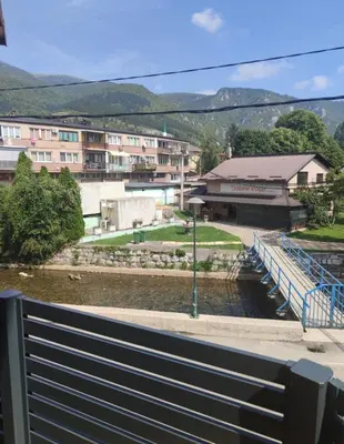 a bridge over a river with buildings in the background at Apartman Školska in Travnik