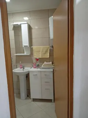 a small bathroom with a sink and a mirror at Apartman Školska in Travnik