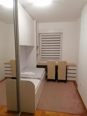 a bedroom with a bed and a table and chairs at Apartman 44, Mejdan, Banja Luka in Banja Luka