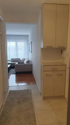 a room with a kitchen and a living room with a couch at Apartman 44, Mejdan, Banja Luka in Banja Luka