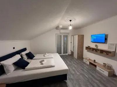 a bedroom with a large bed and a flat screen tv at DM Rooms l in Gornji Vakuf