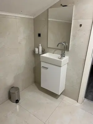 a white bathroom with a sink and a shower at DM Rooms l in Gornji Vakuf