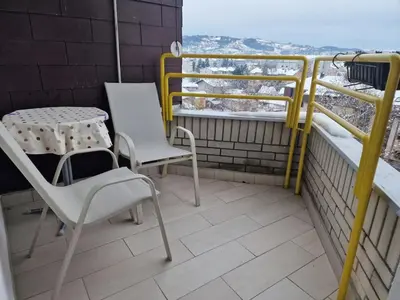 a balcony with a table and chairs and a table and chairs at Apartman Sofija 3 in Starčevica