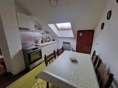 a kitchen with a table and a kitchen with a window at Apartman Sofija 3 in Starčevica
