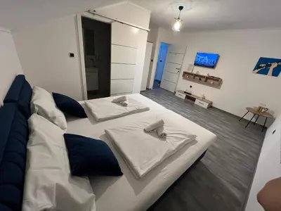 a large white bed with blue pillows in a room at DM Rooms ll in Gornji Vakuf