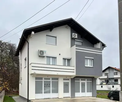 a white house with a black roof at DM Rooms ll in Gornji Vakuf