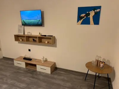 a room with a table and a tv on a wall at DM Rooms ll in Gornji Vakuf