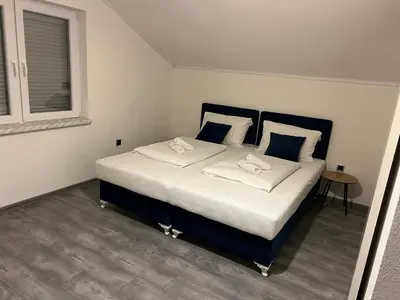 a bedroom with a large bed with white sheets and pillows at DM Rooms ll in Gornji Vakuf
