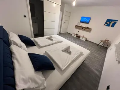 two white beds in a room with blue pillows at DM Rooms ll in Gornji Vakuf