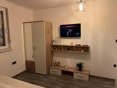 a bathroom with a cabinet and a tv on the wall at DM Rooms lll in Gornji Vakuf
