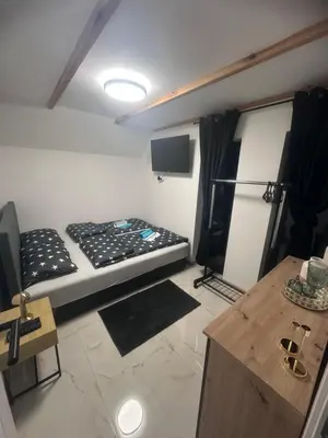 a small room with a bed and a tv in it at Villa Perla in Prijedor