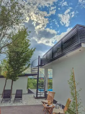 a spiral staircase on the side of a house with chairs at Villa Perla in Prijedor