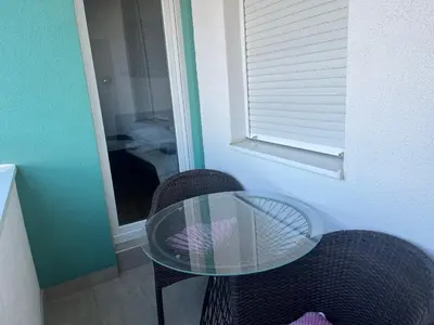 a glass table and two chairs in a room at Apartman Dona in Banja Luka