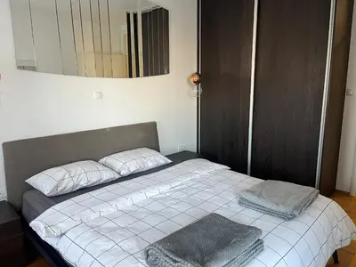 a bed with two pillows and a mirror on the wall at Apartman Dona in Banja Luka