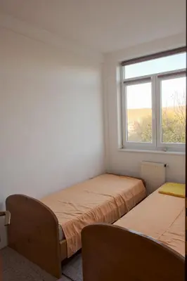 two beds in a room with a window at Banja Luka Lux in Banja Luka