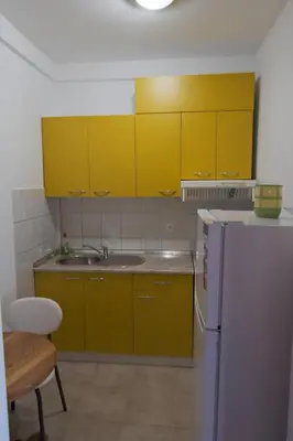 a kitchen with yellow cabinets and a white refrigerator at Banja Luka Lux in Banja Luka