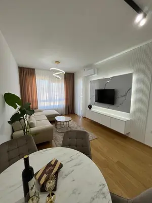 a living room with a table and a couch and a tv at Gold Panorama Apartment 27 in Banja Luka