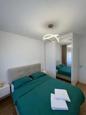 a bedroom with a large bed with blue pillows at Gold Panorama Apartment 27 in Banja Luka