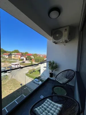 a balcony with a table and chairs and a large window at Gold Panorama Apartment 27 in Banja Luka