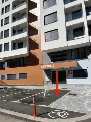 a parking lot in front of a building with a red arrow at Gold Panorama Apartment 27 in Banja Luka