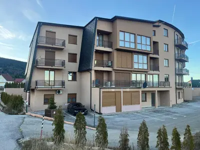 an apartment building with a parking lot in front of it at Aurea Vista in Kupres