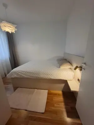 a bedroom with a bed and a door with a rug at Apartman MYKA sa privatnim parkingom in Banja Luka
