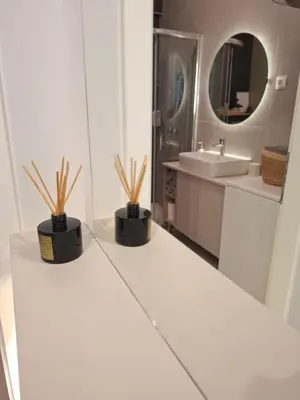a white bathroom with two potted plants on a counter at Apartman MYKA sa privatnim parkingom in Banja Luka