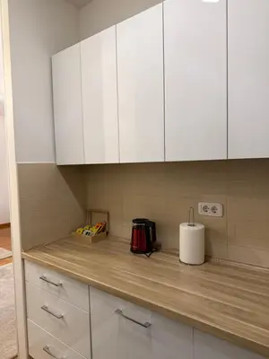 a kitchen with white cabinets and a counter top at Hogar Cálido in Banja Luka