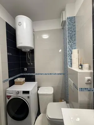 a bathroom with a washing machine and a toilet at Hogar Cálido in Banja Luka