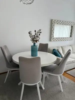 a dining room with a white table and chairs at Hogar Cálido in Banja Luka