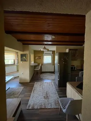 a kitchen and living room with a refrigerator and a table at Panonska jezera ZELENA OAZA in Tuzla