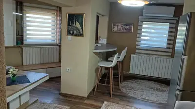 a small kitchen with a table and chairs in a room at Panonska jezera ZELENA OAZA in Tuzla