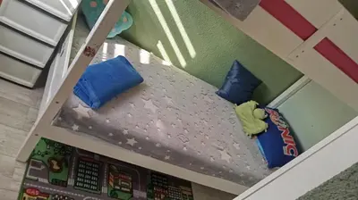 a dollhouse bunk bed with two blue pillows at Panonska jezera ZELENA OAZA in Tuzla