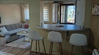a kitchen and living room with a table and chairs at Panonska jezera ZELENA OAZA in Tuzla