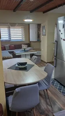 a kitchen and living room with a table and a refrigerator at Panonska jezera ZELENA OAZA in Tuzla