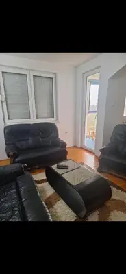 a living room with a black couch and a window at Stan Banja Luka Nova Godina in Krndija