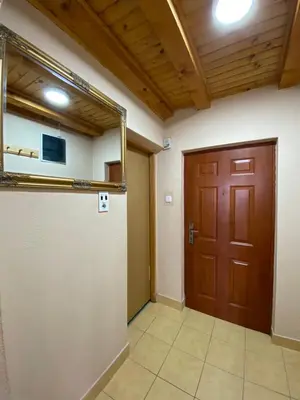 a hallway with a wooden door and a room at Apartments Vlašić Eco in Šišava