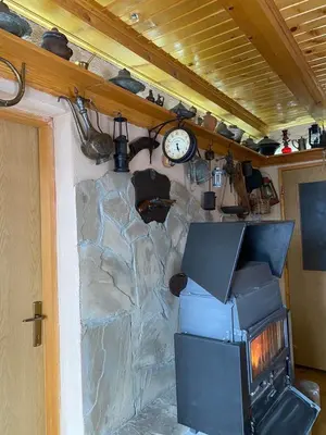 a stone wall with a fireplace and a clock at Apartments Vlašić Eco in Šišava