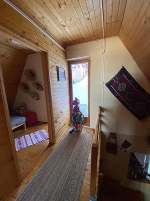 a room with a christmas tree in the middle of a house at Apartments Vlašić Eco in Šišava