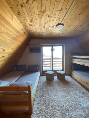 a bedroom with two beds and a wooden ceiling at Apartments Vlašić Eco in Šišava