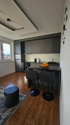 a kitchen with a table and two stools in a room at Stan na dan Jović in Modriča