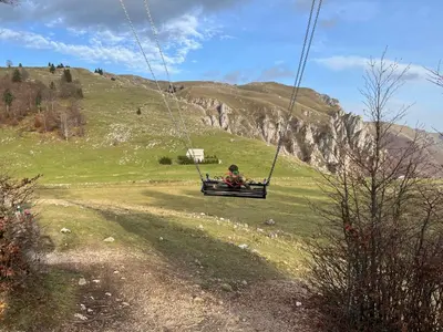 a person sitting in a swing in a field at Planinska Draga Vlašić in Vlasic
