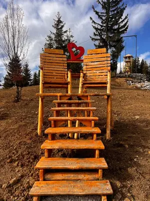 a group of wooden chairs sitting on top of a hill at Planinska Draga Vlašić in Vlasic