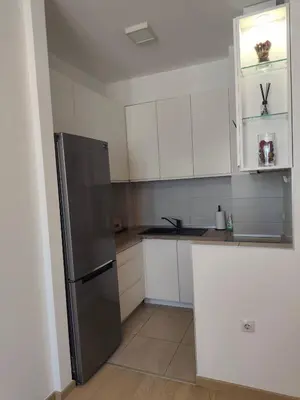 a kitchen with white cabinets and a stainless steel refrigerator at Gray Heaven Retreat in Banja Luka