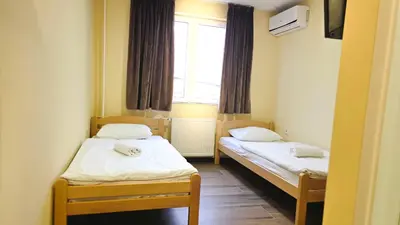 two beds in a small room with a window at City Hostel Banja Luka in Banja Luka