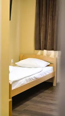 a bed with two pillows on it in front of a window at City Hostel Banja Luka in Banja Luka