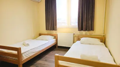 two beds in a small room with a window at City Hostel Banja Luka in Banja Luka
