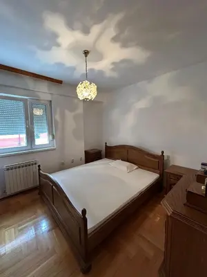 a bedroom with a bed and a chandelier at KT Apartment City Centar in Banja Luka