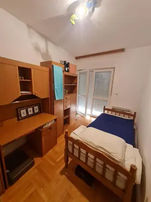 a bedroom with a bed and a desk and a television at KT Apartment City Centar in Banja Luka